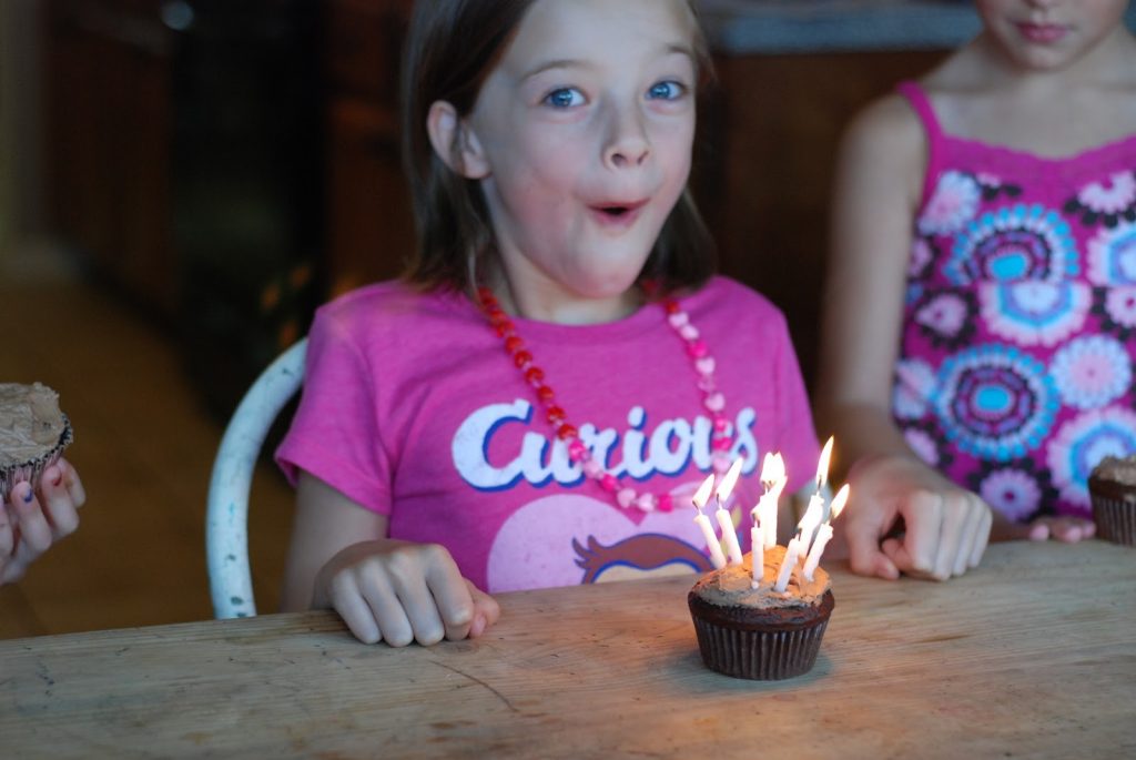 girl with a birthday cupcake and candles